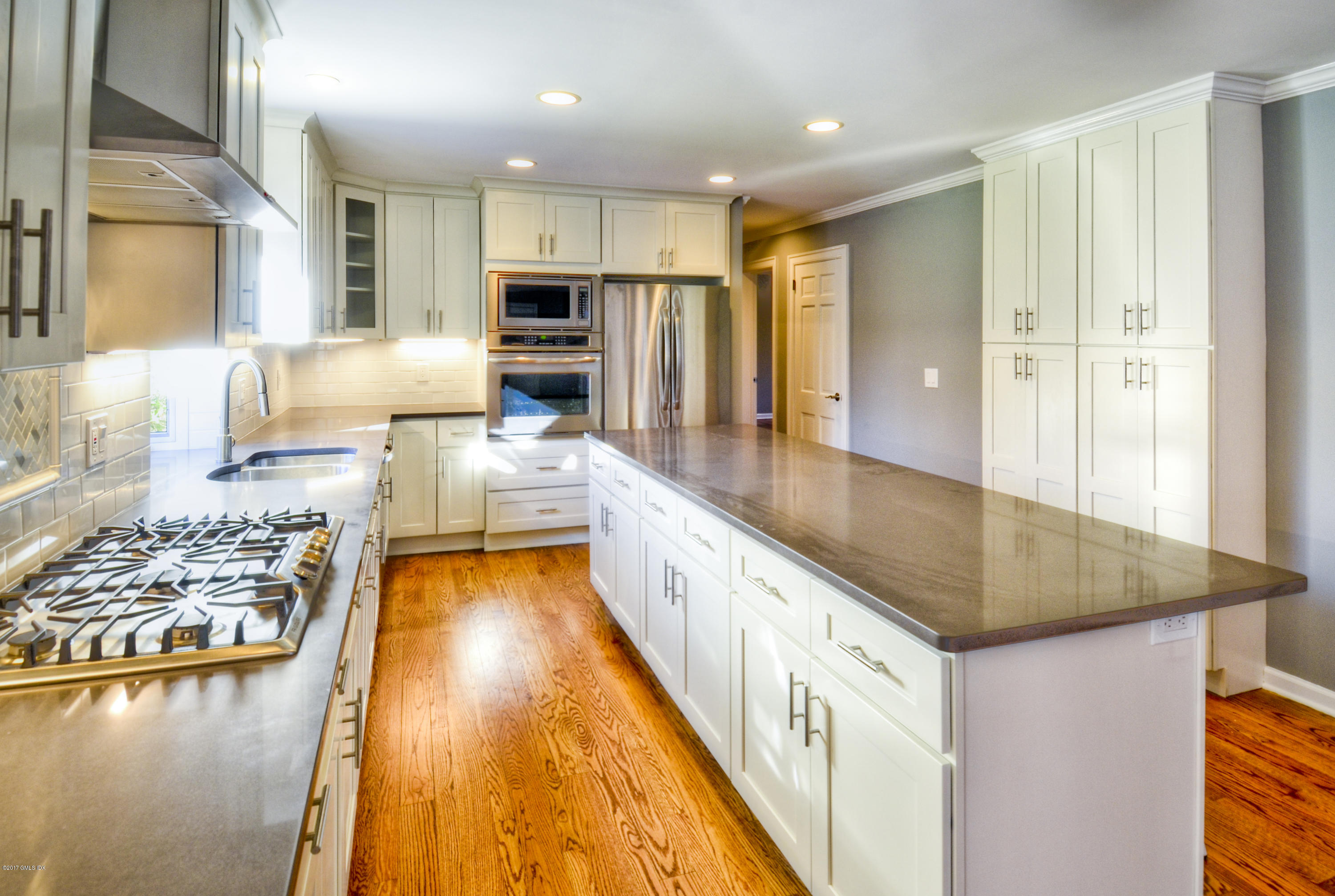 49 Ritch Drive Ridgefield, CT 06877 - Photo 3 of 24 a large white kitchen with kitchen island a large counter top and stainless steel appliances
