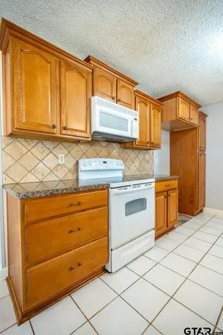 a kitchen with granite countertop cabinets stainless steel appliances and a sink
