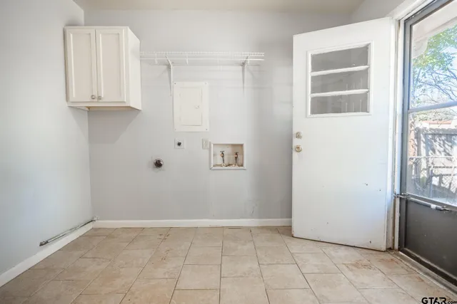 a view of kitchen with white cabinets and window