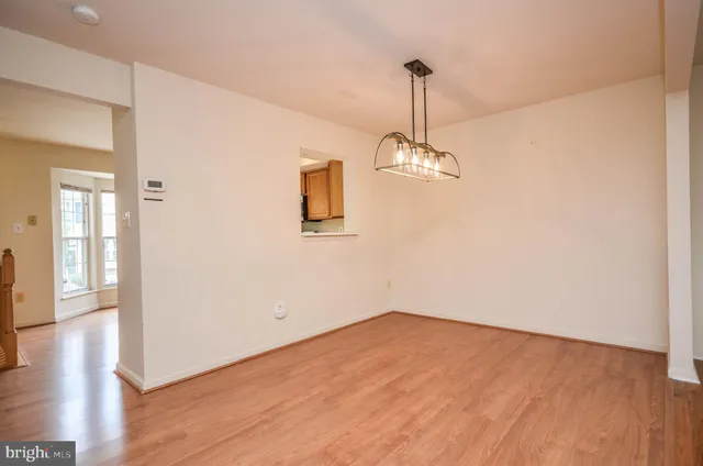 a view of empty room with wooden floor and windows