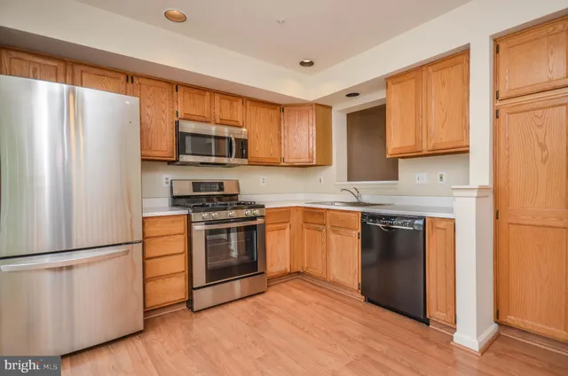 a kitchen with granite countertop a refrigerator stove top oven and sink