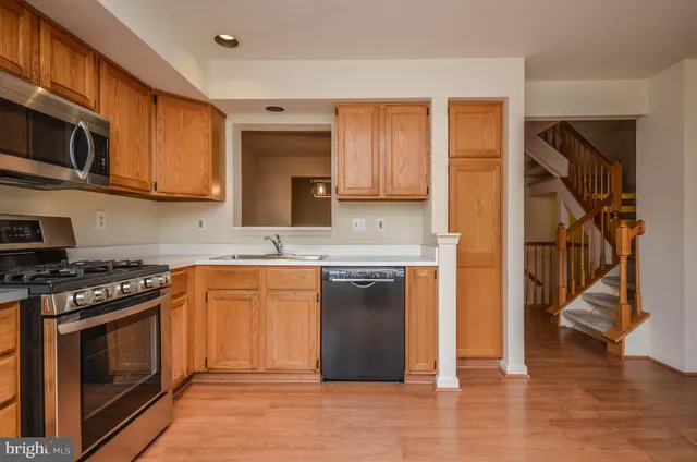 a kitchen with stainless steel appliances granite countertop a stove top oven a sink and a microwave