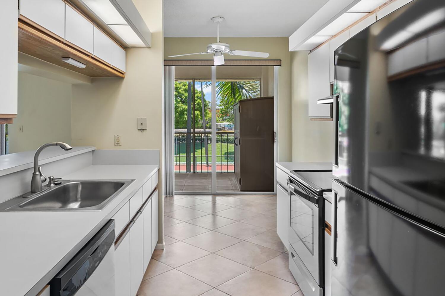 103 Half Moon Circle, Unit D2 Hypoluxo, FL 33462 - Photo 13 of 26 a kitchen that has a sink and a stove