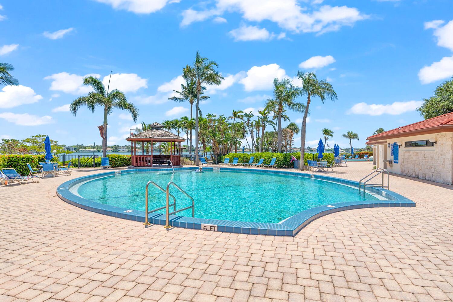 103 Half Moon Circle, Unit D2 Hypoluxo, FL 33462 - Photo 17 of 26 a view of a swimming pool with a lounge chairs