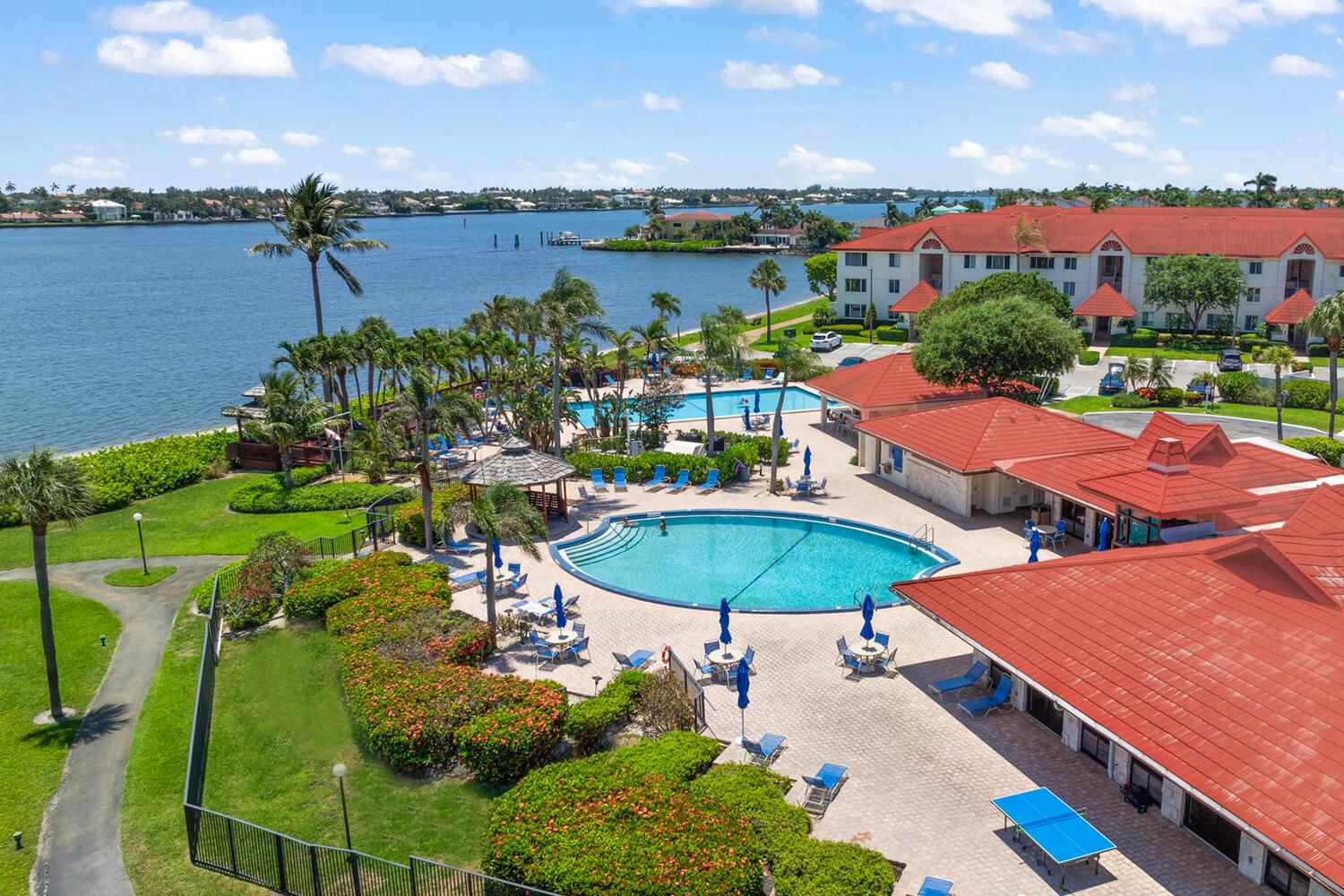 103 Half Moon Circle, Unit D2 Hypoluxo, FL 33462 - Photo 2 of 26 a view of a swimming pool and outside seating area