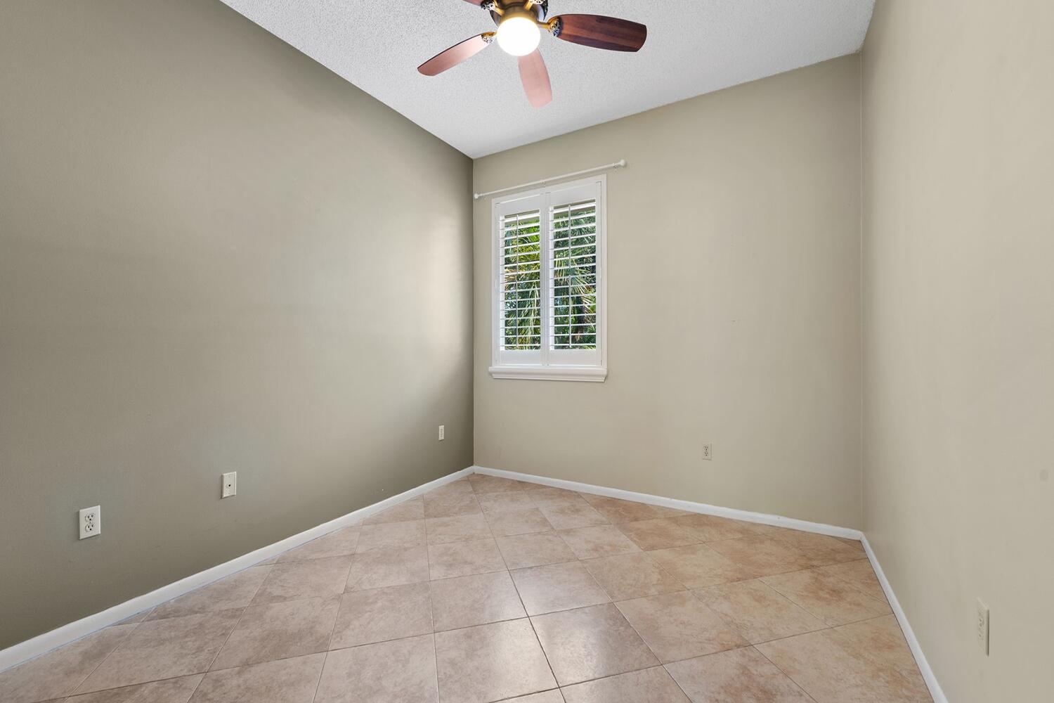 103 Half Moon Circle, Unit D2 Hypoluxo, FL 33462 - Photo 10 of 26 an empty room with a chandelier fan and windows