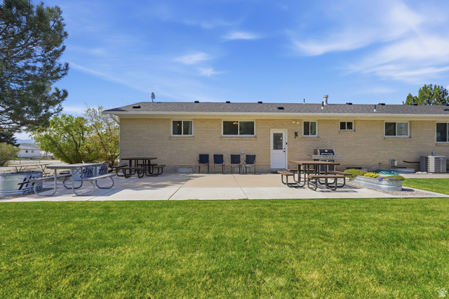 2420 West Old Hwy Road Morgan, UT 84050 - Photo 44 of 54 Back of property with a patio area, a lawn, and brick siding