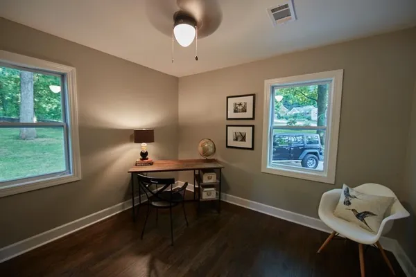 a view of a workspace with furniture and a window