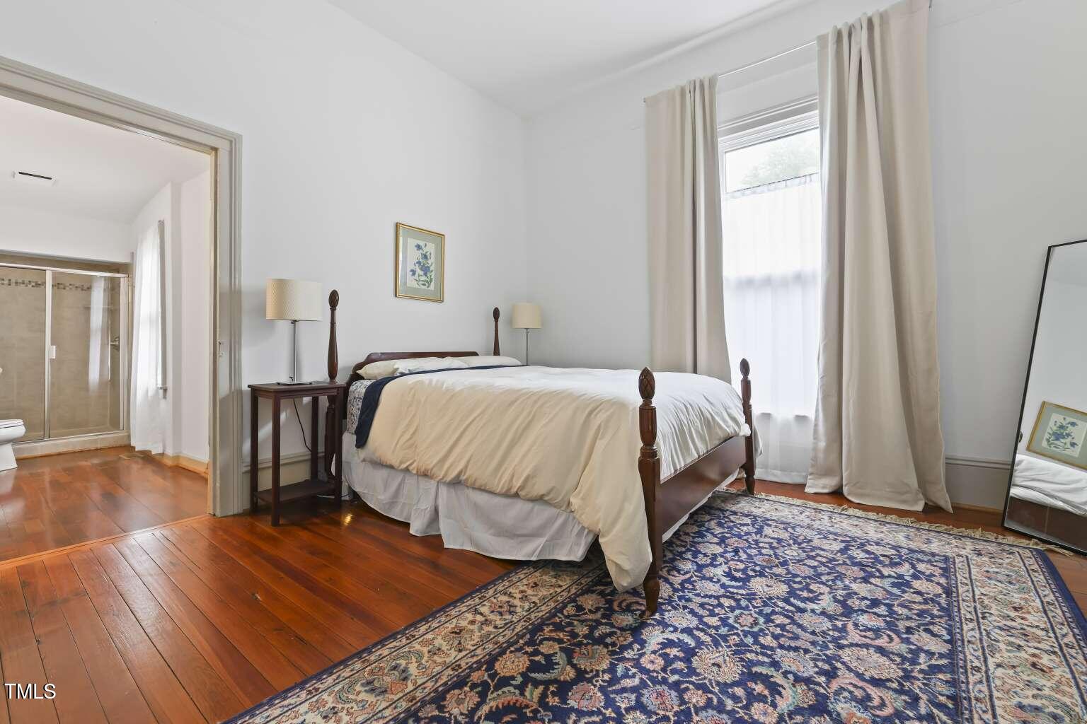 304 Linden Avenue Raleigh, NC 27601 - Photo 13 of 33 a bedroom with a bed and wooden floor