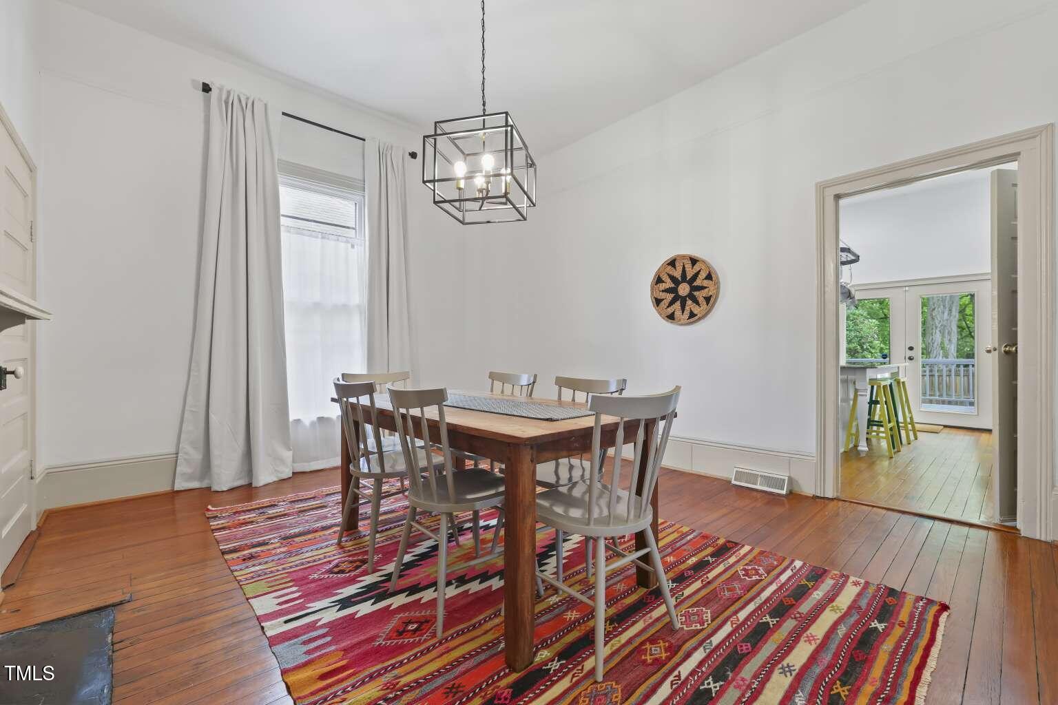 304 Linden Avenue Raleigh, NC 27601 - Photo 17 of 33 a view of a dining room with furniture wooden floor and a chandelier