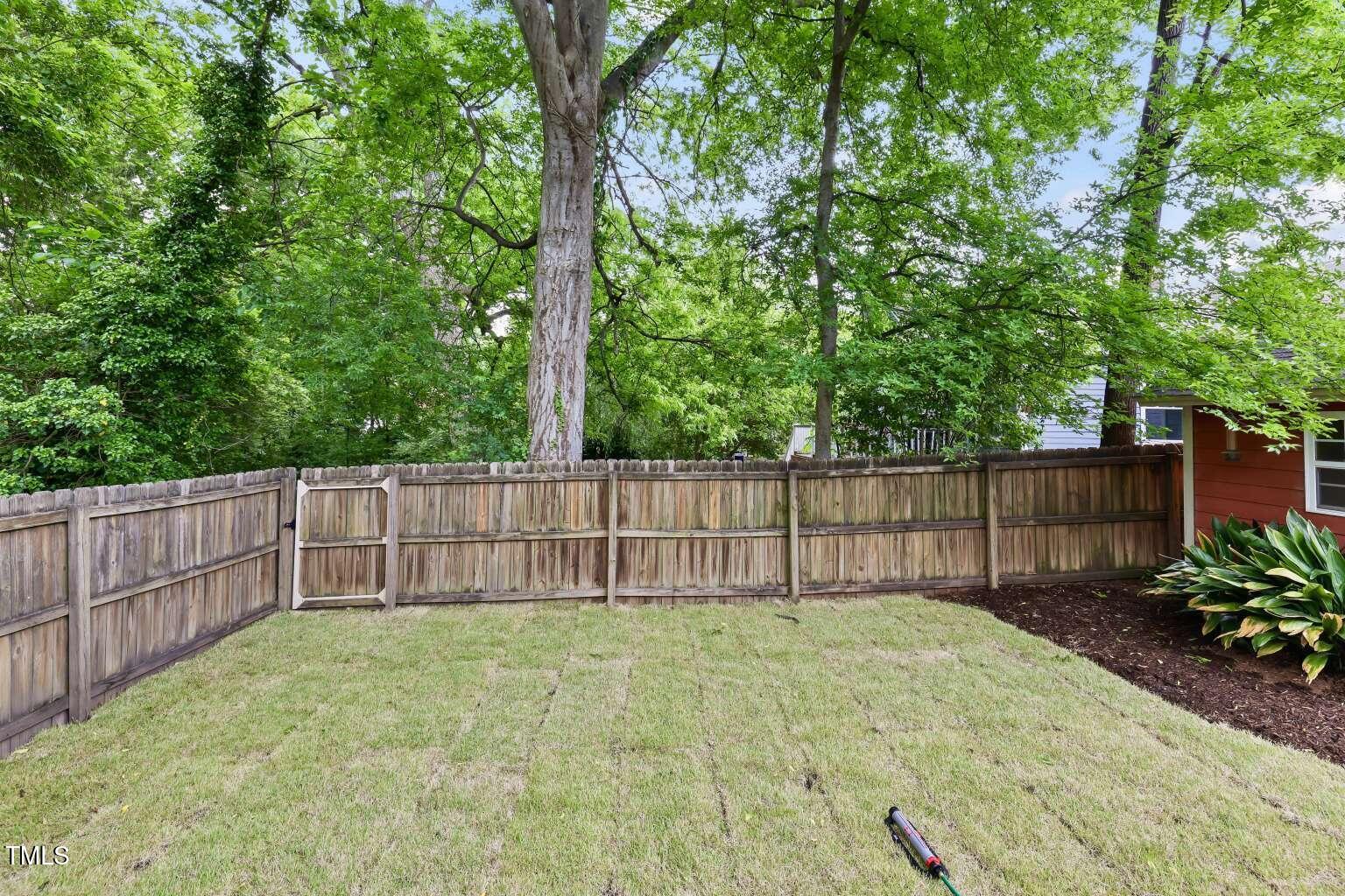 304 Linden Avenue Raleigh, NC 27601 - Photo 29 of 33 a view of a backyard with a large trees and wooden fence