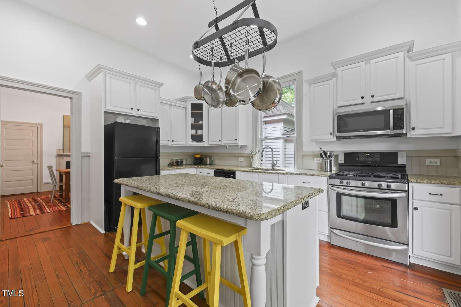 304 Linden Avenue Raleigh, NC 27601 - Photo 6 of 33 a kitchen with stainless steel appliances granite countertop a sink a stove a refrigerator cabinets and wooden floor
