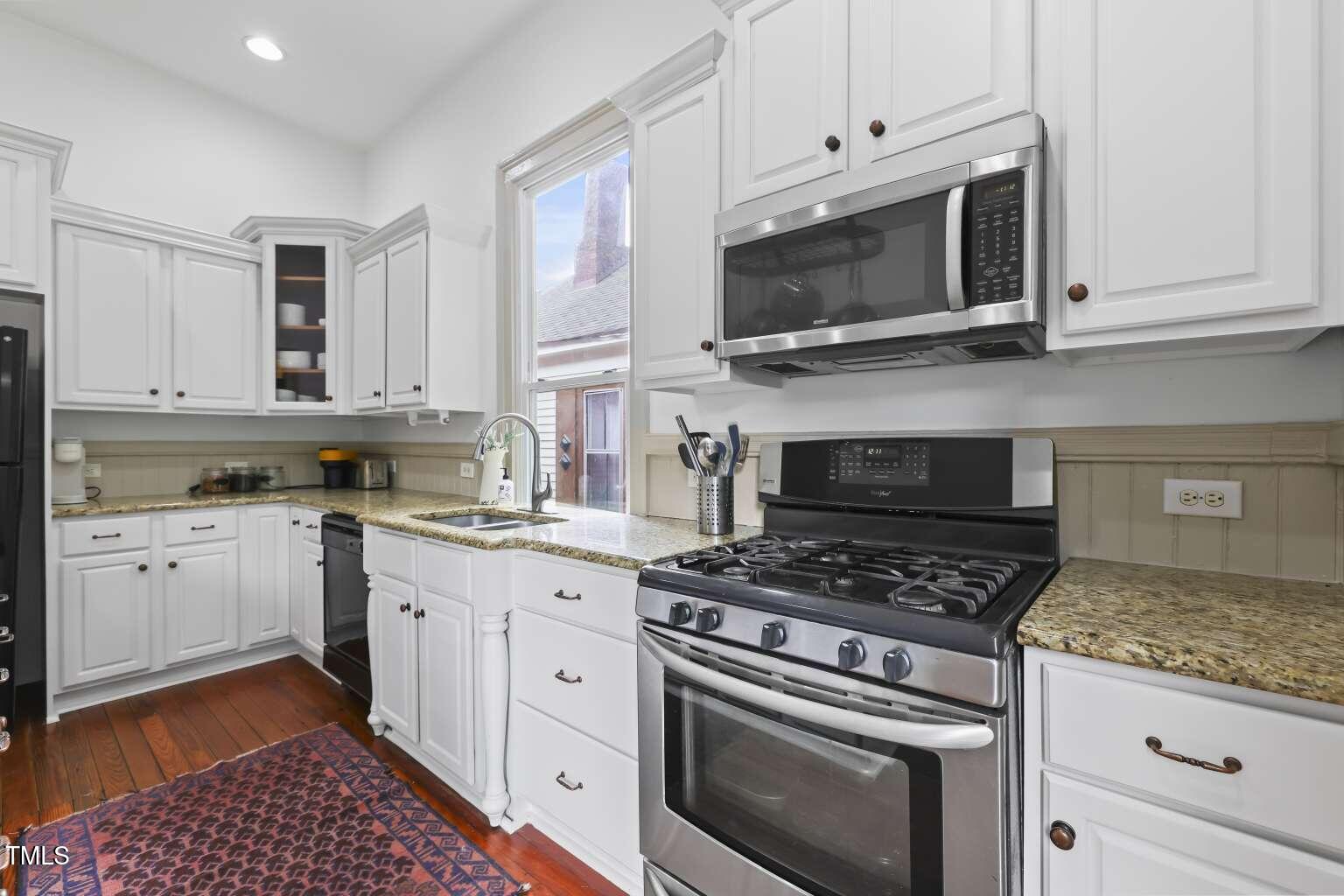 304 Linden Avenue Raleigh, NC 27601 - Photo 7 of 33 a kitchen with stainless steel appliances granite countertop grey cabinets a stove a sink and dishwasher
