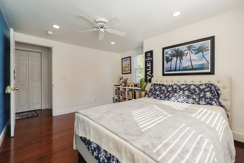 2 Rhodes Avenue Sharon, MA 02067 - Photo 28 of 42 a bedroom with a large bed and a chandelier