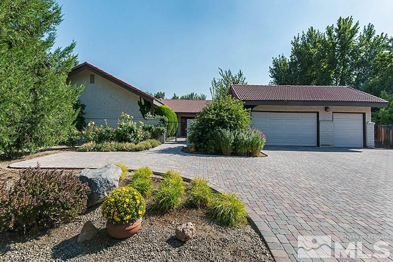 a front view of a house with a yard and a garden
