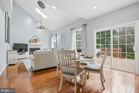 a view of a dining room with furniture a chandelier and wooden floor