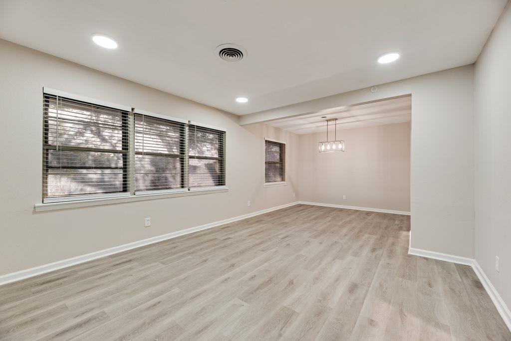 5706 Rocky Ridge Road Dallas, TX 75241 - Photo 5 of 31 an empty room with wooden floor and windows