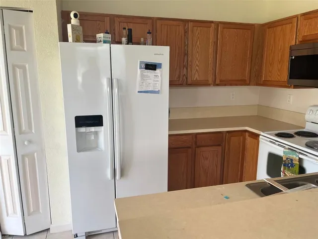 a kitchen with a refrigerator sink and cabinets