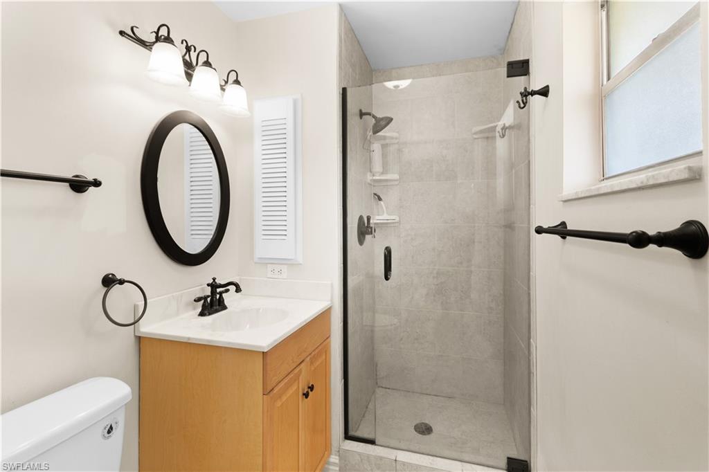 7225 Jasmine Road Fort Myers, FL 33967 - Photo 16 of 24 a bathroom with a sink a mirror a glass door shower and mirror