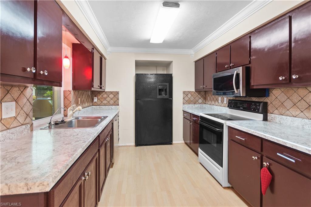 7225 Jasmine Road Fort Myers, FL 33967 - Photo 7 of 24 a kitchen with stainless steel appliances granite countertop a sink a stove and a wooden cabinets