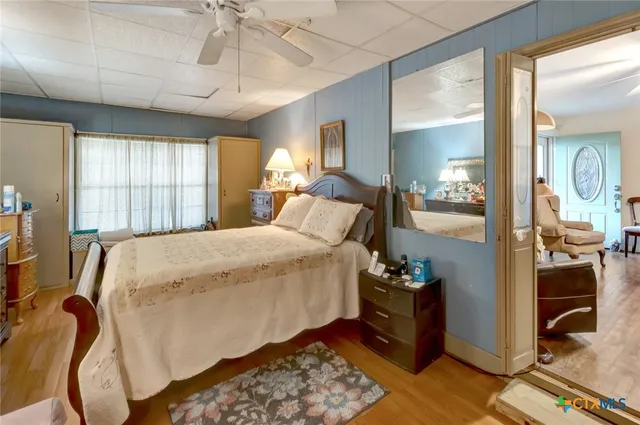 a bed sitting in a spacious bedroom next to a window