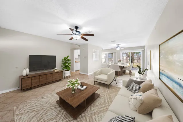 a living room with furniture a flat screen tv and a large window