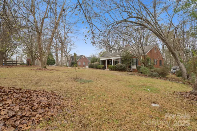 a view of house with yard and trees in the background