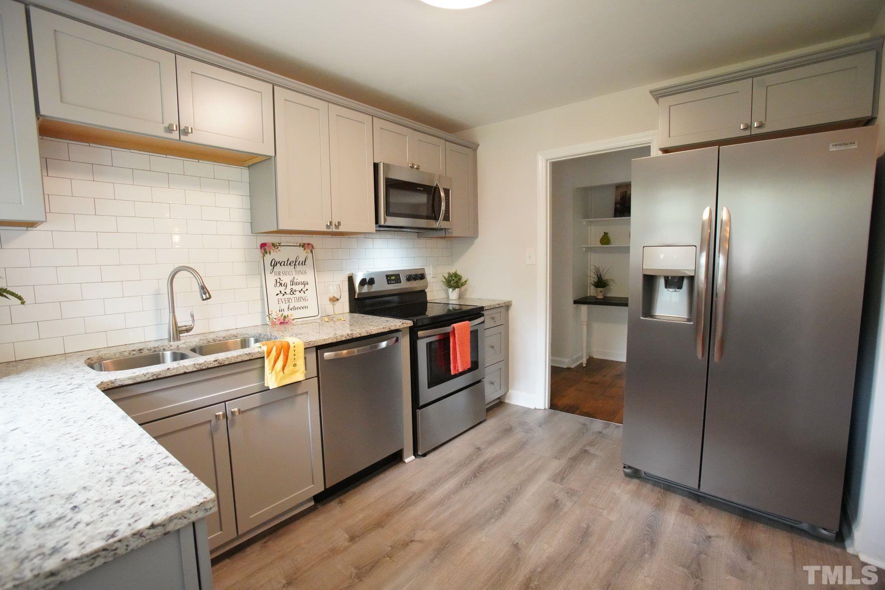 1206 Downing Road Raleigh, NC 27610 - Photo 6 of 15 a kitchen with stainless steel appliances granite countertop a refrigerator a sink a stove and oven