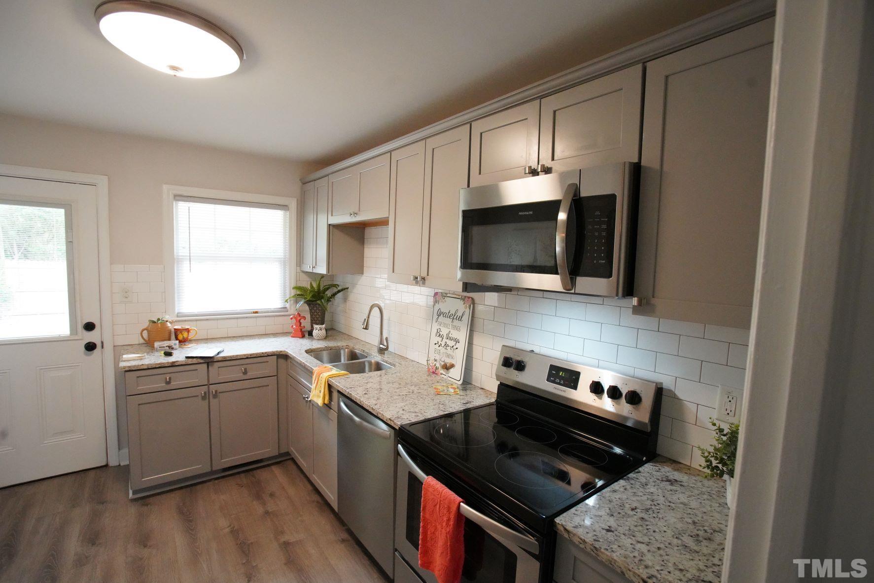 1206 Downing Road Raleigh, NC 27610 - Photo 7 of 15 a kitchen with a sink stove and microwave