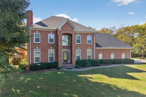 a front view of a house with yard and green space