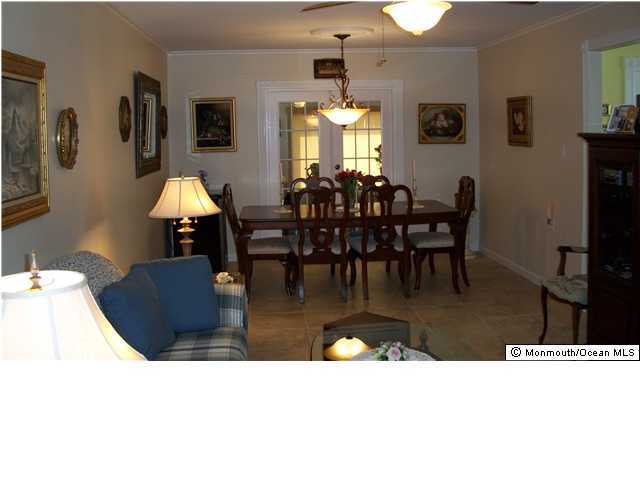 17 Brooke Road Brick, NJ 08724 - Photo 3 of 3 a view of dining room and livingroom with furniture a rug a potted plant and a fireplace