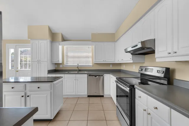 a kitchen with stainless steel appliances granite countertop a sink and a stove
