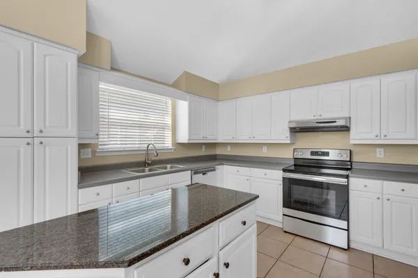a kitchen with stainless steel appliances granite countertop a refrigerator a sink and a stove