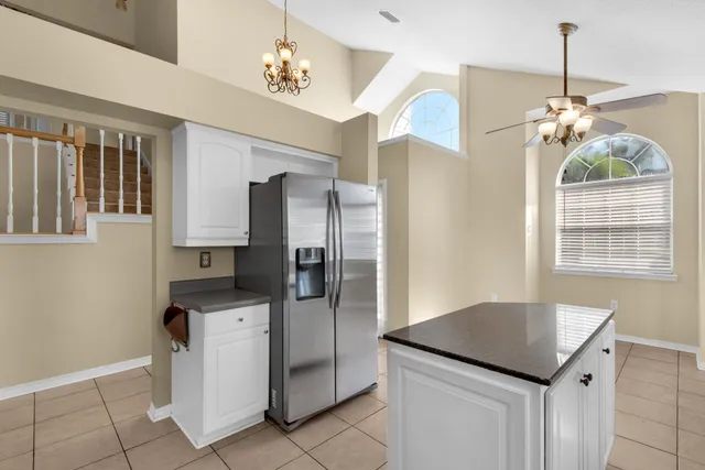 a kitchen with kitchen island granite countertop a refrigerator oven a sink and dishwasher