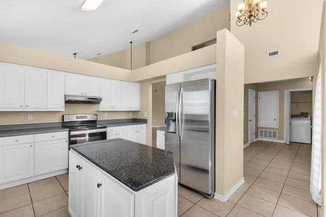 a kitchen with granite countertop a sink a stove and cabinets