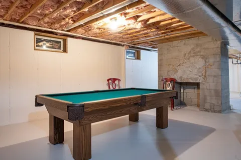a room with pool table and windows