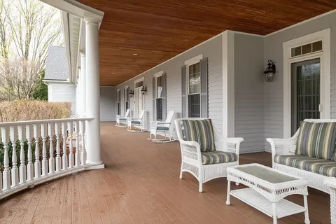 a view of a patio with couches chairs and wooden floor