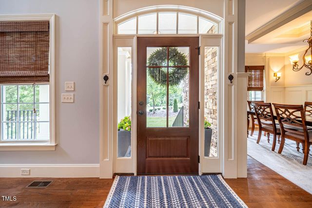 a view of a hallway with a dining room and wooden floor