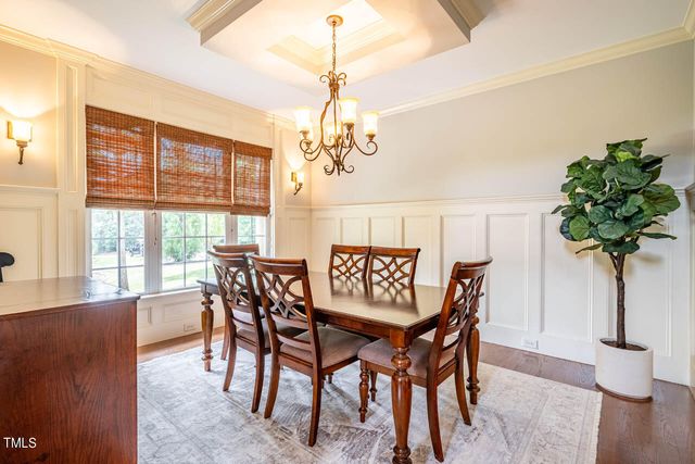 a dining room with furniture potted plants and wooden floor