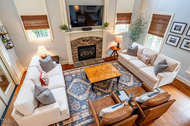 a living room with furniture a flat screen tv and a fireplace