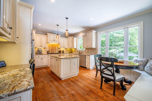 a kitchen with a table chairs sink and cabinets