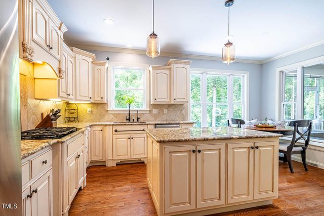 a kitchen with stainless steel appliances granite countertop a stove a sink and a wooden floors
