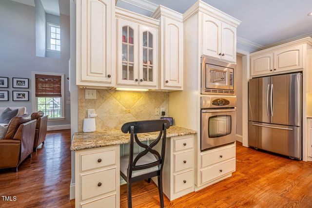 a kitchen with granite countertop a refrigerator and a stove top oven