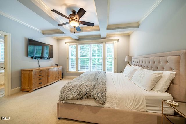 a spacious bedroom with a bed and a flat screen tv