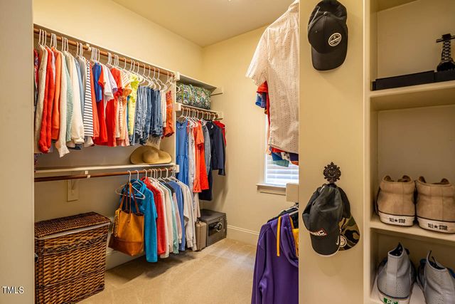 a view of walk in closet with clothes and shoes