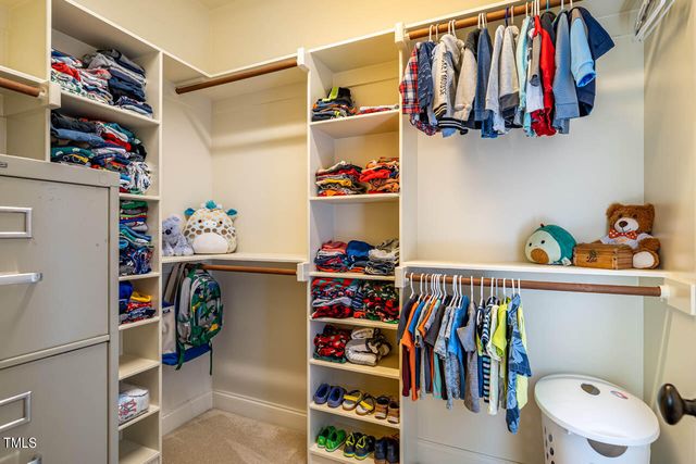 a view of walk in closet with clothes and shoes