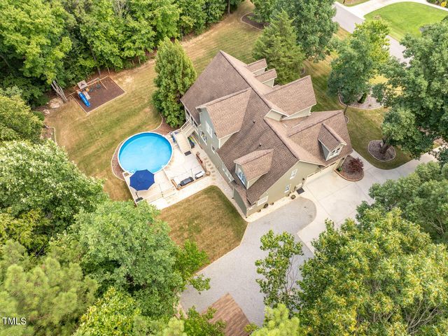 an aerial view of a house with a swimming pool and garden view