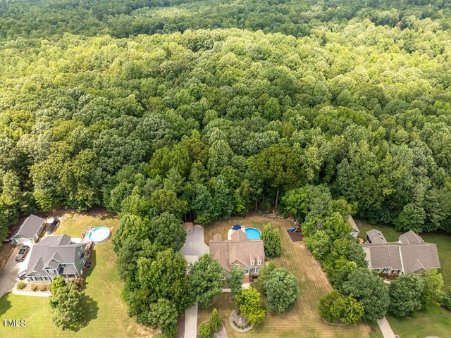 an aerial view of a house with a yard and lake view