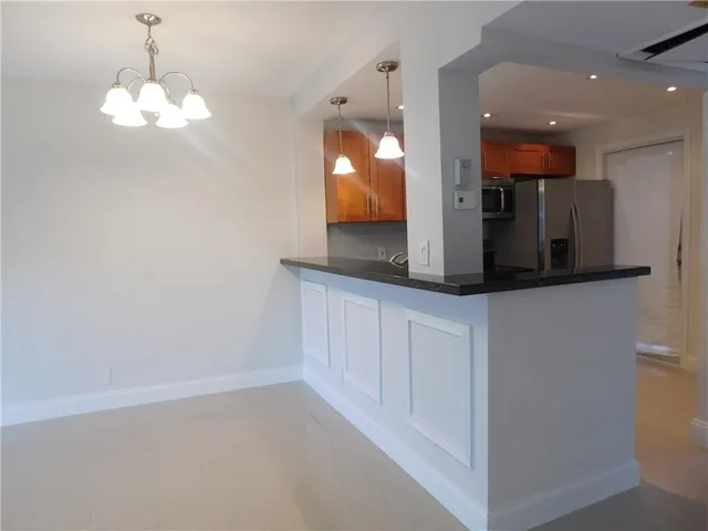 a view of a kitchen with a sink and chandelier