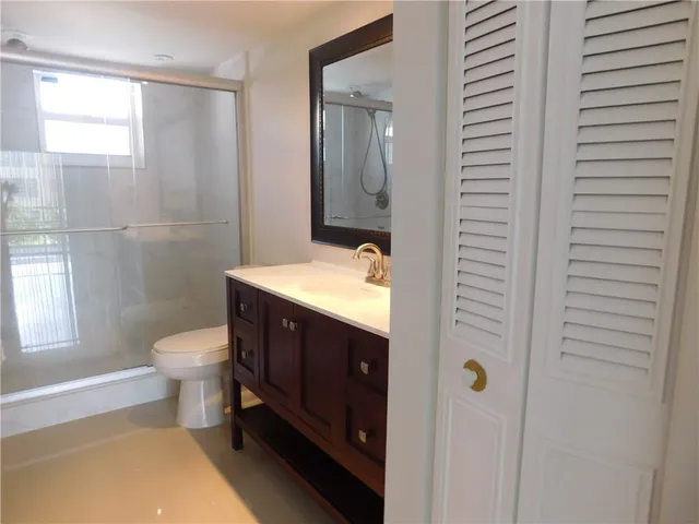 a bathroom with a double vanity sink toilet and shower